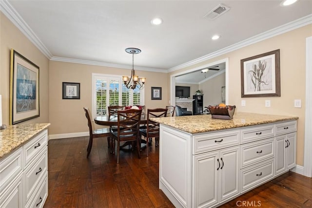 kitchen featuring visible vents, baseboards, white cabinets, ornamental molding, and dark wood finished floors