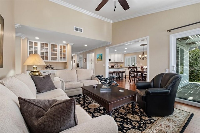 living room featuring a healthy amount of sunlight, visible vents, and ornamental molding