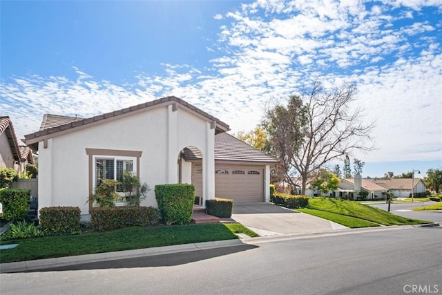 view of front facade featuring driveway, a tiled roof, an attached garage, and stucco siding