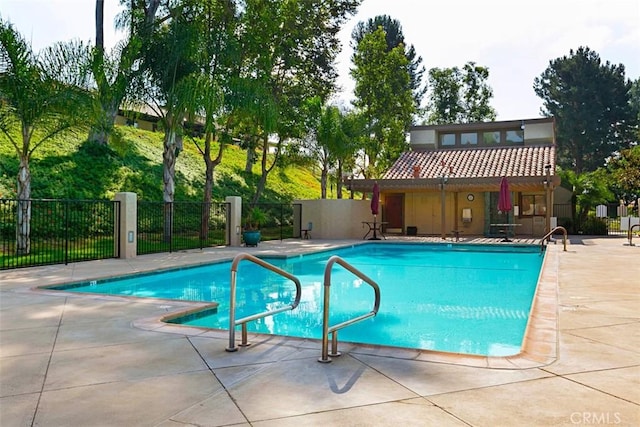 community pool featuring a patio area and fence