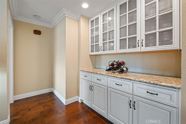 bar featuring crown molding, dark wood-style flooring, recessed lighting, and baseboards