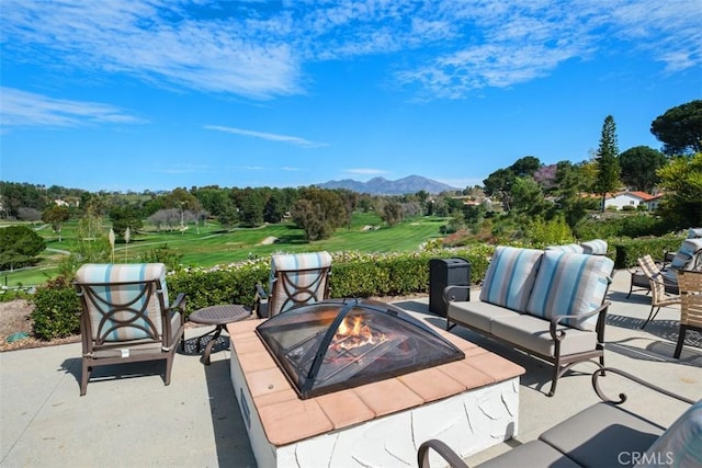 view of patio with an outdoor living space with a fire pit and a mountain view