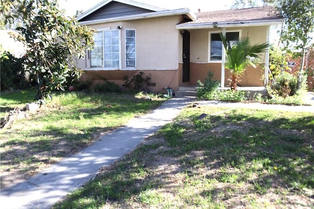 view of front of home with a front yard and stucco siding