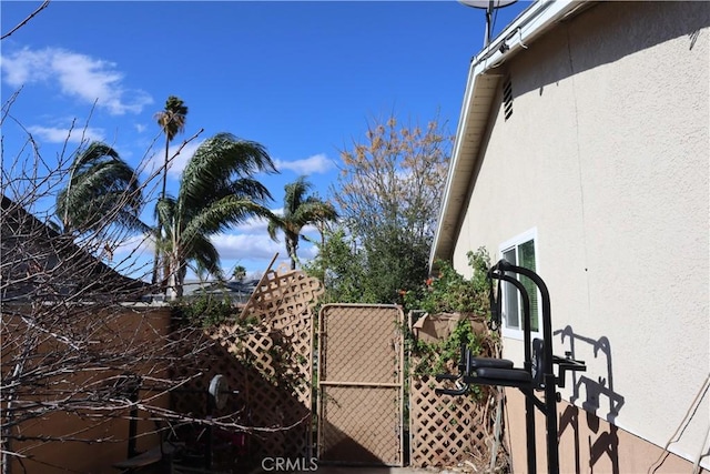 view of home's exterior featuring a gate, fence, and stucco siding