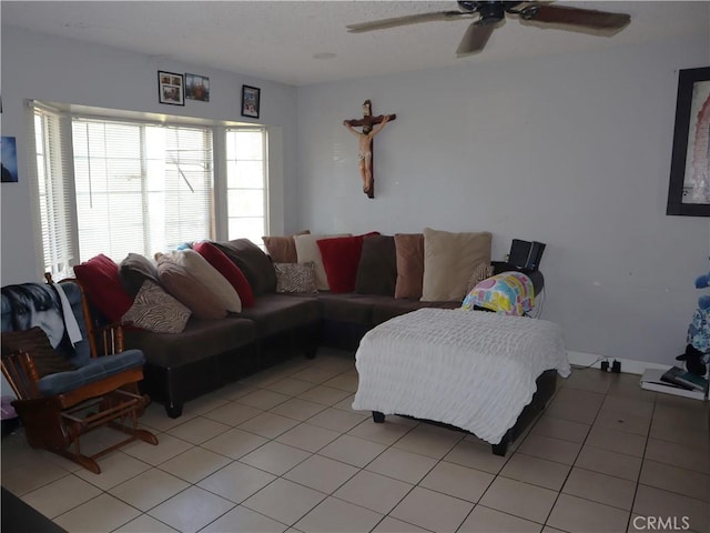 living area with a ceiling fan and light tile patterned flooring