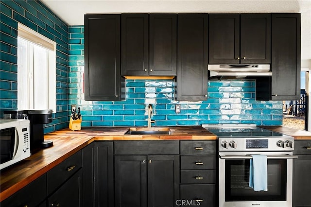 kitchen with white microwave, stainless steel range with electric stovetop, a sink, butcher block countertops, and under cabinet range hood