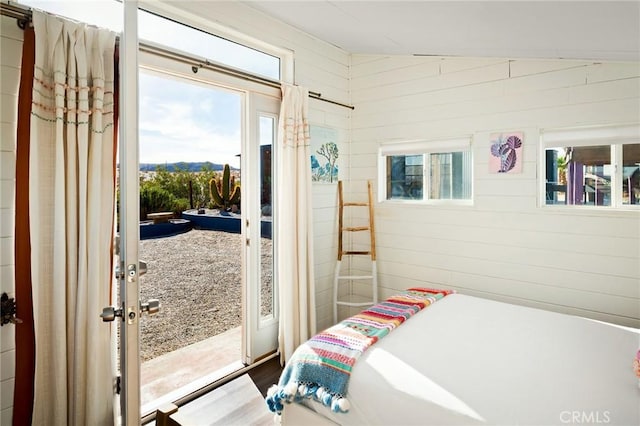 bedroom featuring access to exterior and wooden walls