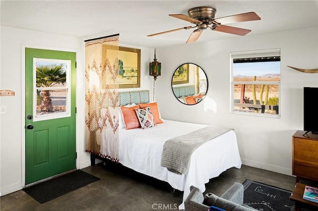 bedroom featuring finished concrete flooring, ceiling fan, and baseboards