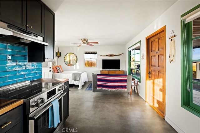 kitchen featuring concrete flooring, dark cabinets, electric stove, and under cabinet range hood