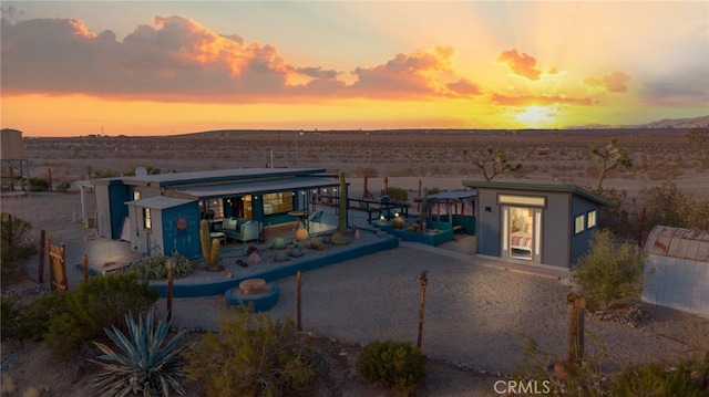 back of property with view of desert and a mountain view