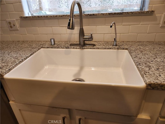 42397 Santiago Dr, Hemet, CA 92544 - room details with backsplash, light stone countertops, and a sink