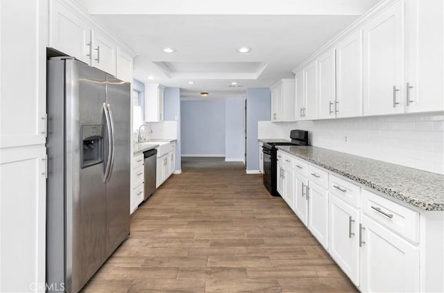 42397 Santiago Dr, Hemet, CA 92544 - kitchen with a tray ceiling, appliances with stainless steel finishes, decorative backsplash, and white cabinets