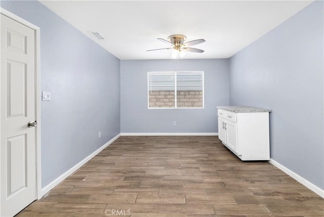42397 Santiago Dr, Hemet, CA 92544 - unfurnished room with wood finished floors, visible vents, a ceiling fan, and baseboards