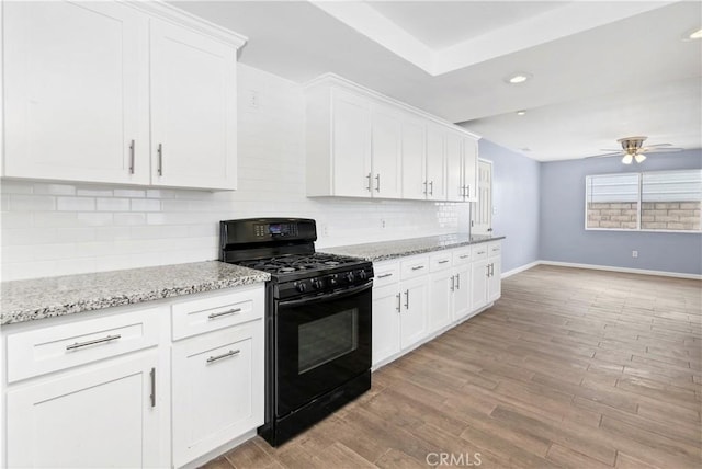 42397 Santiago Dr, Hemet, CA 92544 - kitchen featuring tasteful backsplash, ceiling fan, baseboards, white cabinetry, and black gas range