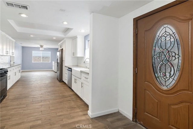 42397 Santiago Dr, Hemet, CA 92544 - kitchen with white cabinets, visible vents, a raised ceiling, and appliances with stainless steel finishes