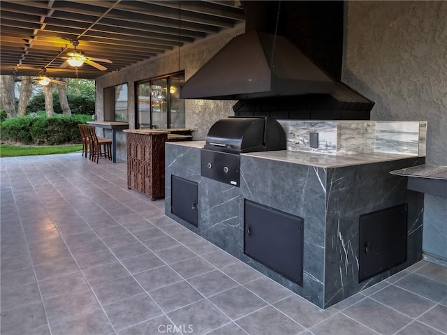 view of patio / terrace featuring area for grilling, ceiling fan, an outdoor kitchen, and outdoor wet bar