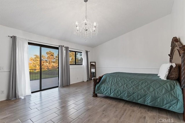 bedroom featuring wood finished floors, access to outside, vaulted ceiling, a textured ceiling, and a chandelier