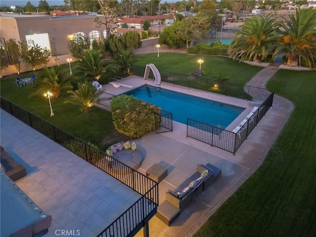 view of swimming pool featuring a patio, a water slide, fence, and a fenced in pool