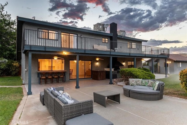 rear view of house with a balcony, outdoor dry bar, outdoor lounge area, and a patio