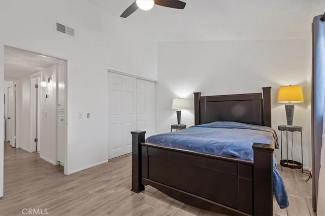 bedroom with a ceiling fan, visible vents, baseboards, a closet, and light wood-type flooring