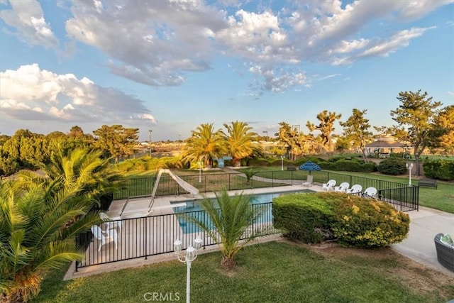 view of swimming pool with a patio area, a fenced in pool, fence, and a water slide