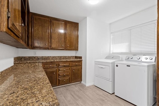 laundry area with light wood-type flooring and washing machine and clothes dryer