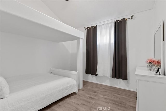 bedroom featuring lofted ceiling and light wood-style floors