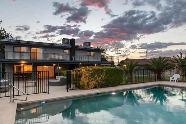 view of swimming pool featuring a patio area, fence, and a fenced in pool