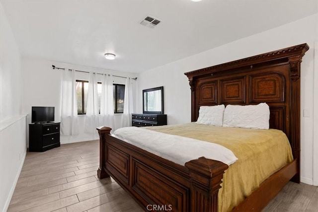 bedroom with visible vents, light wood-style flooring, and baseboards