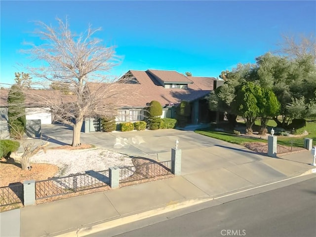 view of front of property with concrete driveway and a fenced front yard