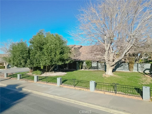 obstructed view of property featuring a fenced front yard and a front yard