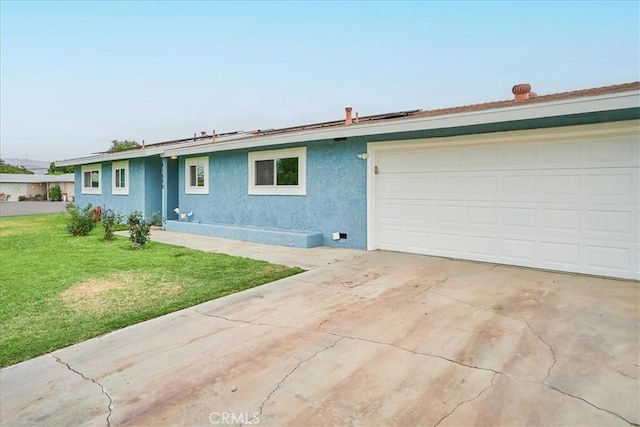 ranch-style home with a front yard, driveway, and stucco siding