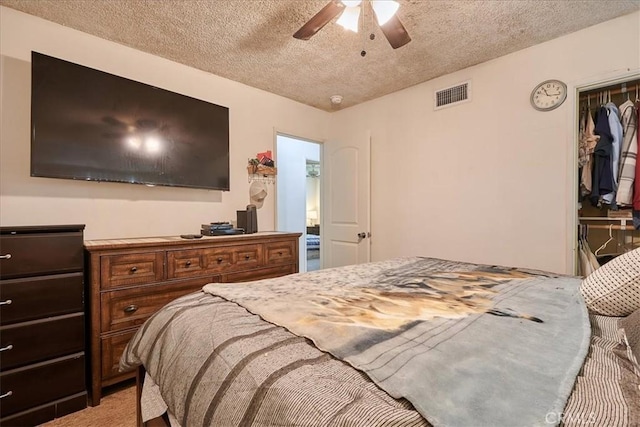 bedroom with light colored carpet, visible vents, ceiling fan, and a textured ceiling