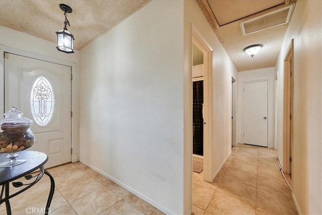 entryway featuring baseboards and a textured ceiling