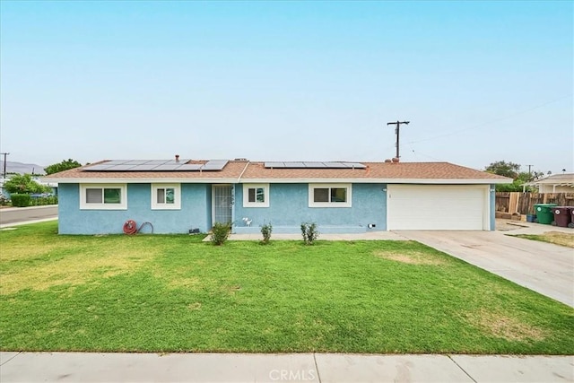 ranch-style home featuring a garage, solar panels, driveway, stucco siding, and a front yard