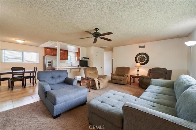 living area featuring a wealth of natural light, visible vents, light carpet, and light tile patterned floors