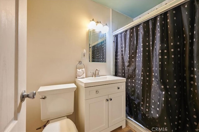 full bathroom featuring a shower with shower curtain, vanity, and toilet