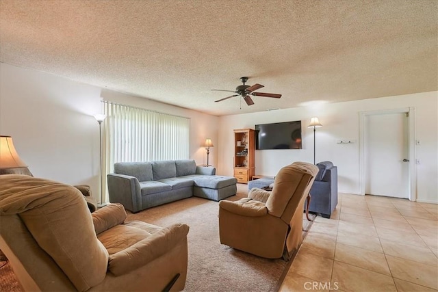 living area with light tile patterned floors, ceiling fan, and a textured ceiling