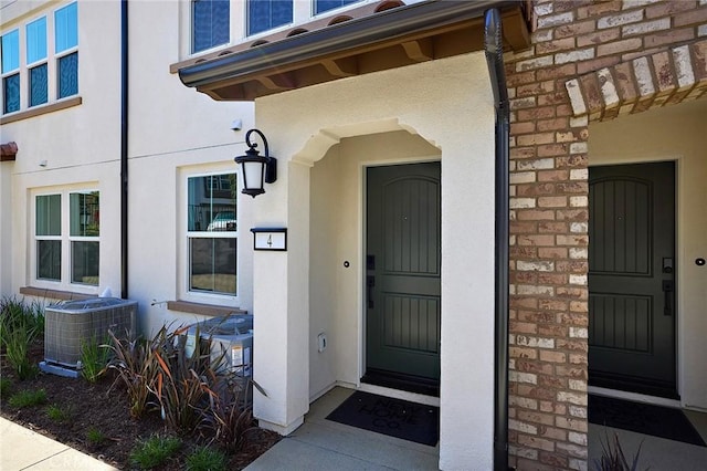 property entrance featuring stucco siding and cooling unit