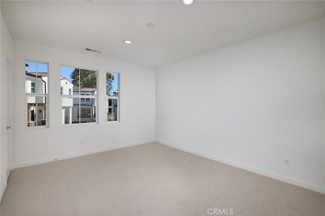 empty room featuring baseboards, light carpet, recessed lighting, and visible vents