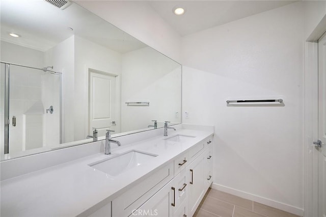 bathroom featuring visible vents, a sink, baseboards, and tile patterned flooring