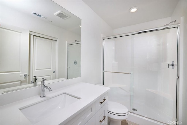 full bathroom featuring vanity, a shower stall, toilet, and visible vents