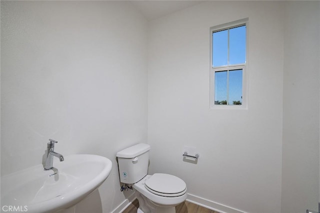 bathroom with baseboards, a sink, and toilet