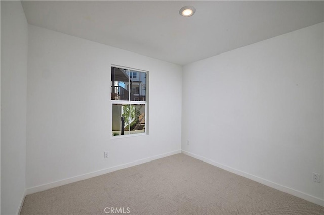 carpeted spare room featuring recessed lighting and baseboards