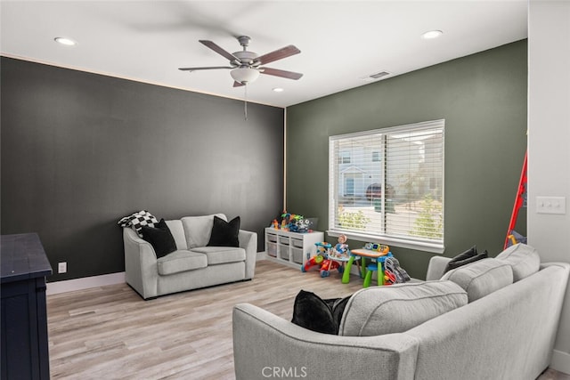 living area with ceiling fan, recessed lighting, visible vents, and light wood-style floors