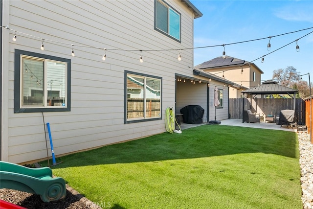 rear view of house featuring a patio, a lawn, a gazebo, and fence