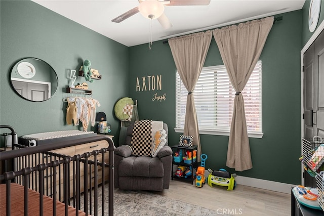 bedroom featuring a ceiling fan, baseboards, and wood finished floors