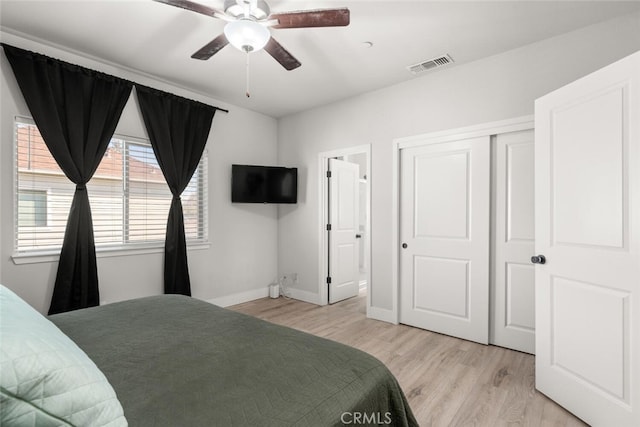 bedroom with baseboards, visible vents, a ceiling fan, light wood-type flooring, and a closet