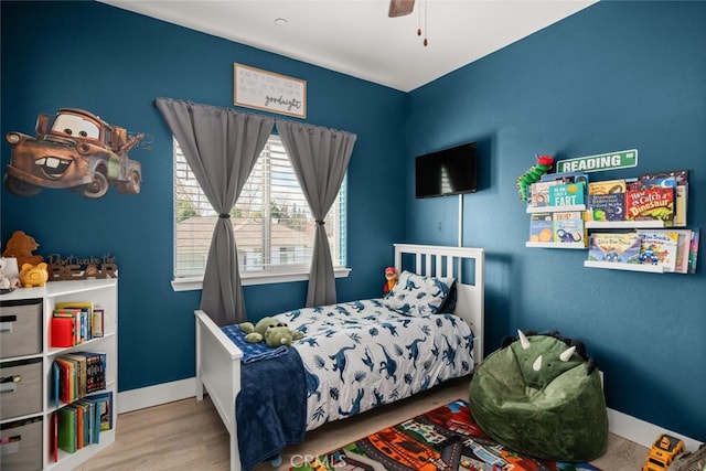 bedroom with wood finished floors, a ceiling fan, and baseboards