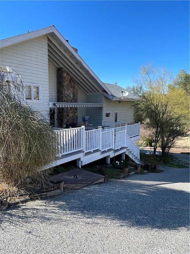 view of property exterior featuring stairway and a deck